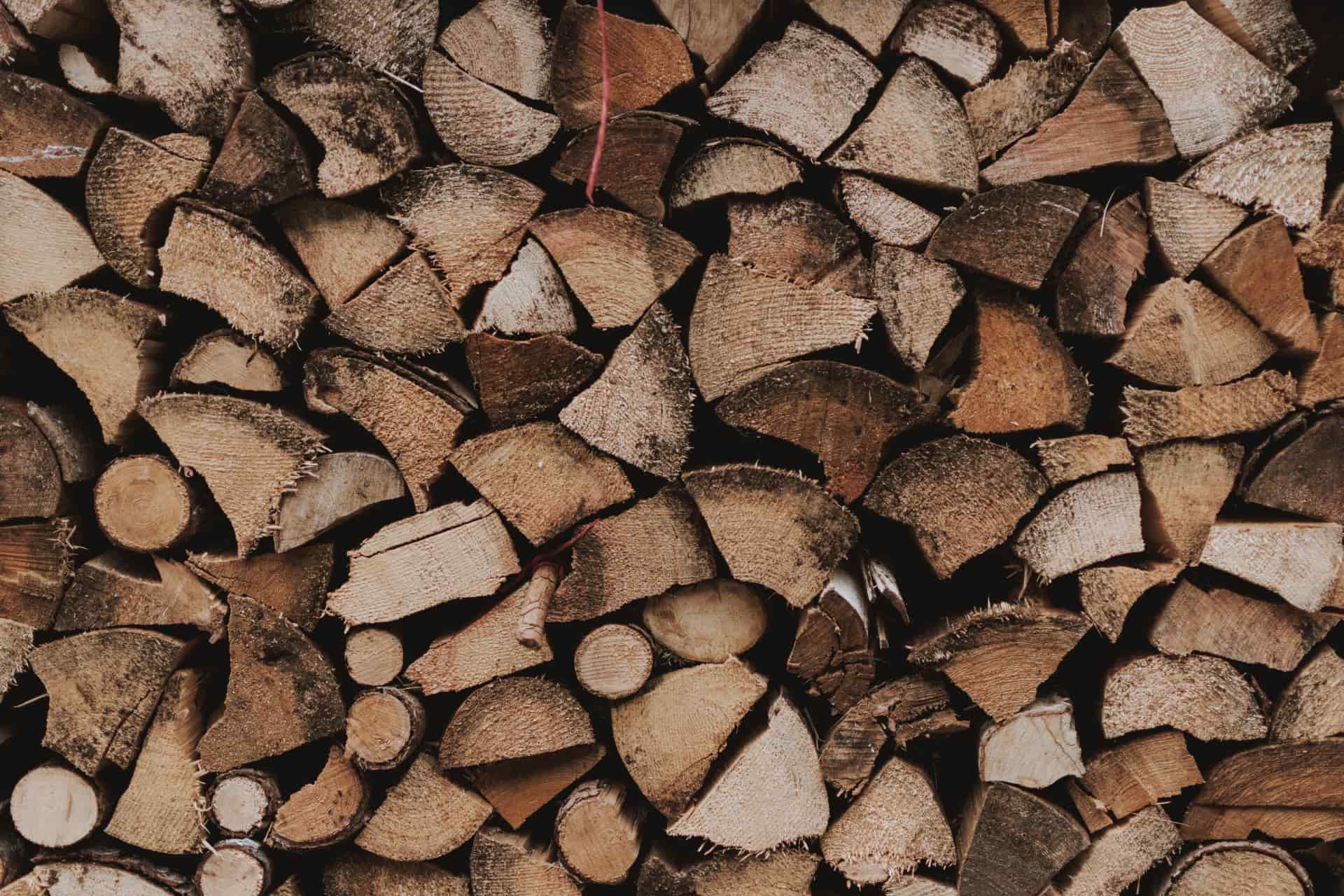 Split hardwood logs and wood smoke in warm, earthy light